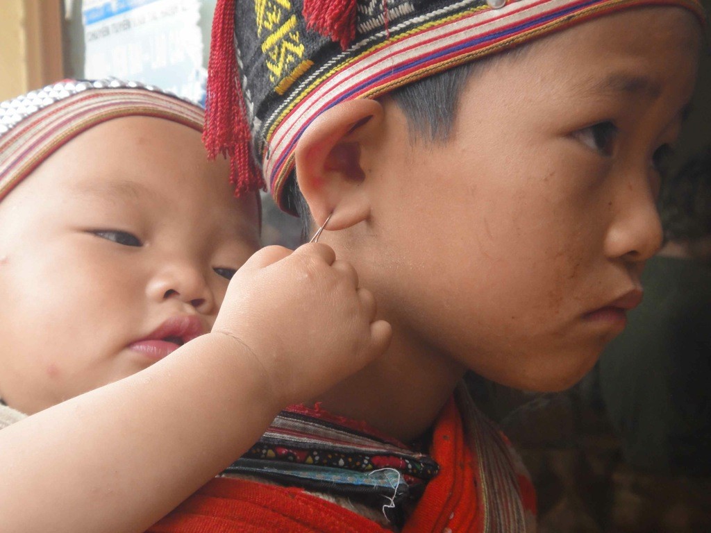 playing_with_her_earring Baby brother playing with his sister's earring: Sapa, Vietnam.