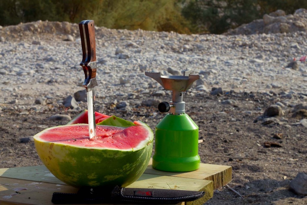 Watermelon, hunting knife and camping stove.