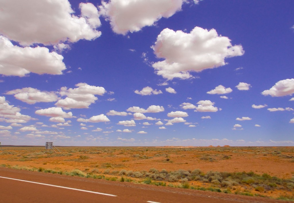 clouds, road and red earth in outback australia.