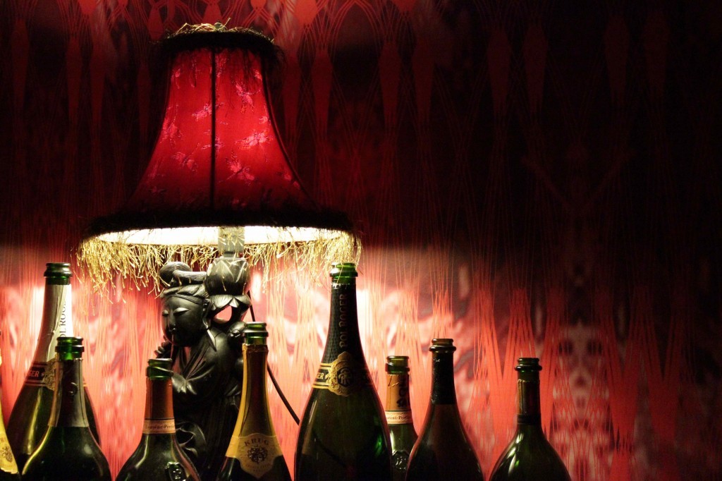 scarlet lampshade illuminates rich walls and champagne bottles at New Gold Mountain, Melbourne