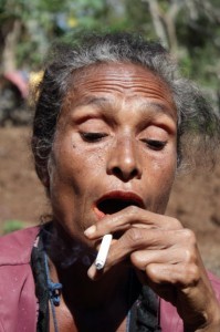 Nome Timor -- woman exhales after smoking a cigarette.