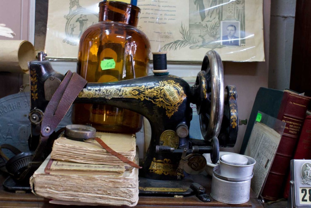 Ancient singer sewing machine and apothecary bottles in antique shop in Plovdiv Old Town.
