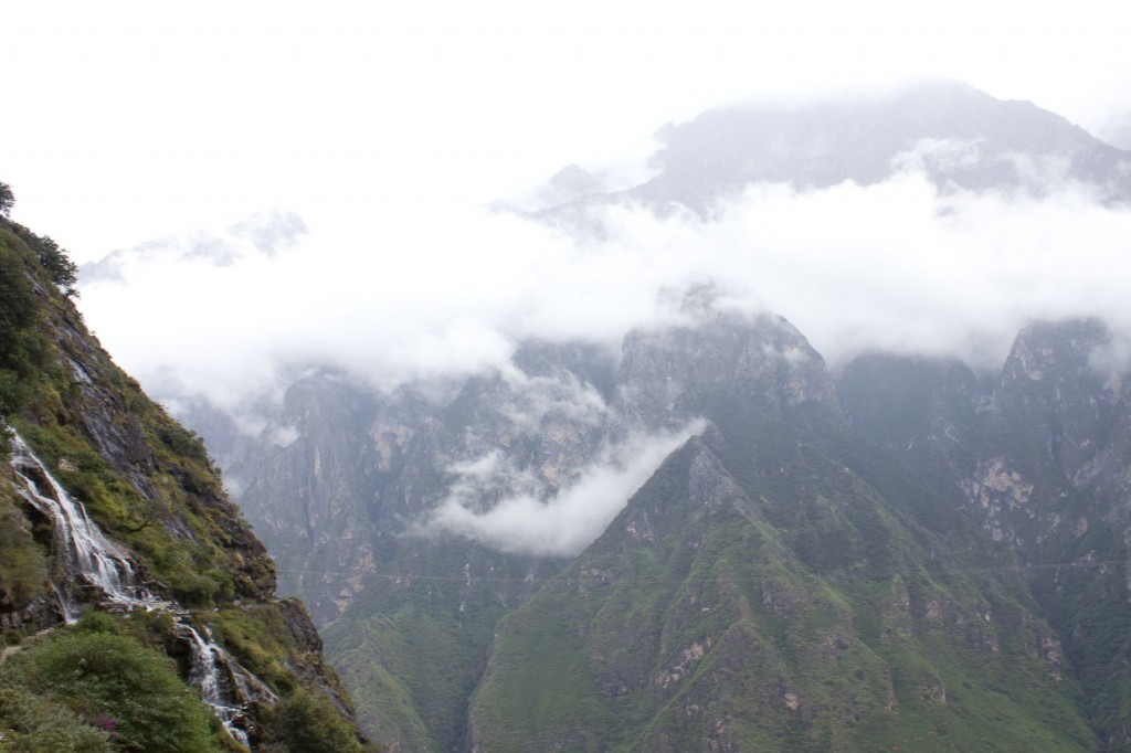 View of waterfall dropping away with mountains in the background, Tiger Leaping Gorge, Yunnan, China.
