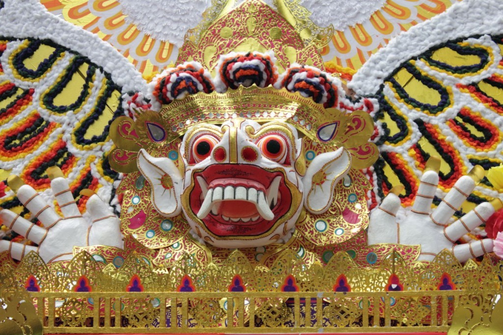 Bali Funeral: the gilded face of protective demon, known as a bhoma, on a funeral tower in Ubud, Bali.