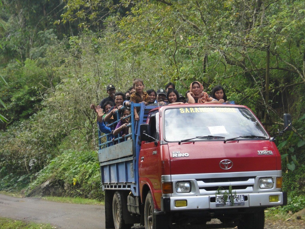cattle truck with waving people, tana toraja Torajans waving from cattle truck en route to funeral. Tana Toraja, Sulawesi, Indonesia.