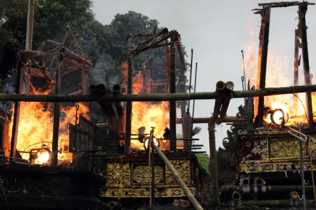Bali cremation: Men tend pyres with kerosene burners.