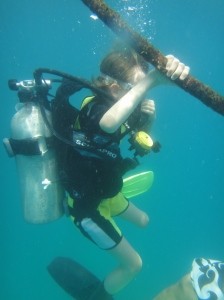 Z descending a guideline under the water in scuba gear, one hand on the rope.
