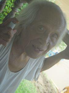 Hundred year old Kayan man watching teams training for the Sarawak regatta. Balui River, Sarawak, Malaysia, Borneo.
