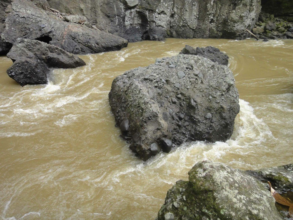 jumping off time, maiting river, sulawesi, indonesia Maiting River swirls around dark rocks in gorge. Tana Toraja, Sulawesi, Indonesia.