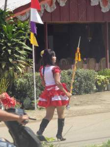 Girl in short skirt and knee boots leading political parade in Rantepao, Sulawesi, Indonesia.