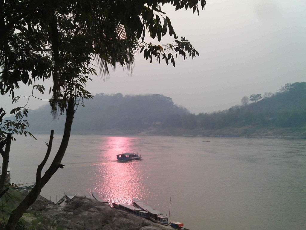 Mekong-Sunset-Luang-Prabang-Laos Sampan in sunset streak on Mekong, Luang Prabang, Laos