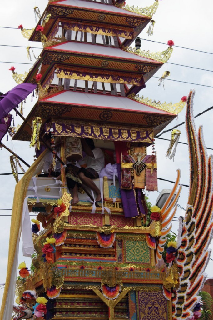 Bali cremation: men ride the coffin in the funeral tower.