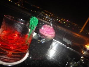 Negroni cocktail and floating rose over Bangkok skyline, Vertigo