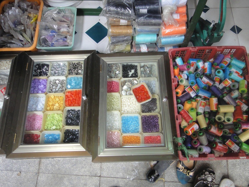 pavement_outside_trimmings_store_hanoi_vietnam Pavement covered in sequins, threads and trimmings. Hanoi, Vietnam.