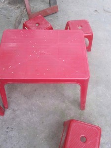 Red kindergarten table and chairs on pavement, Vietnam