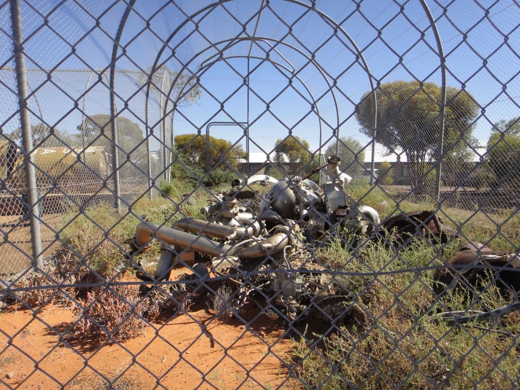 crumpled remains of missile testing in Woomera, South Australia, behind wire fence