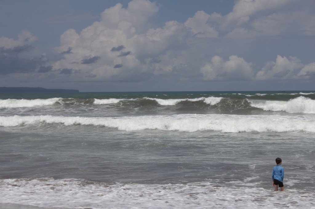small boy, big surf Z in surf on Seminyak beach.