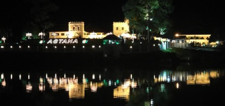 Astana, the fortress-like state residence of the Governor of Sarawak, illuminated at night, reflecting in the Sarawak River. Kuching, Sarawak, Borneo, Malaysia.