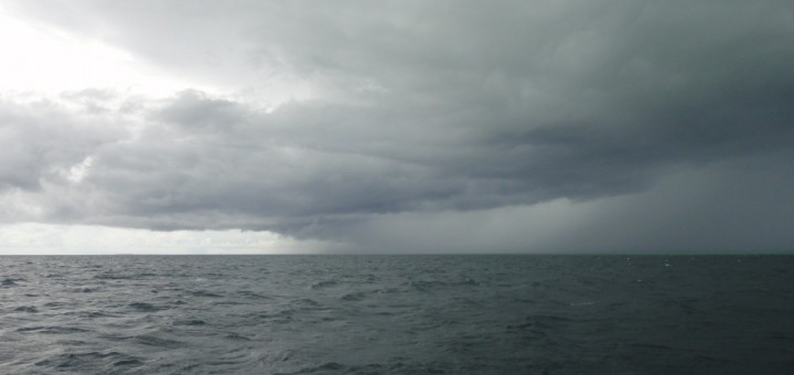 Storm clouds gather over a flat dark sea. Off Pulau Derawan, Indonesia.