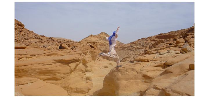 Family travel in Sinai, Egypt: child leaping over a wadi.