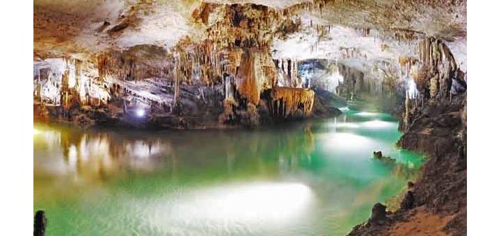 The lower, water-filled cave at Jeita, lights illuminating the stalactites.