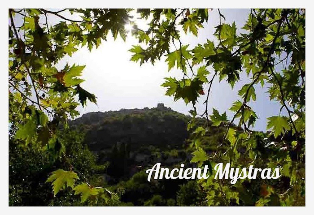 View over the fortified city of Mystras, framed by leaves.