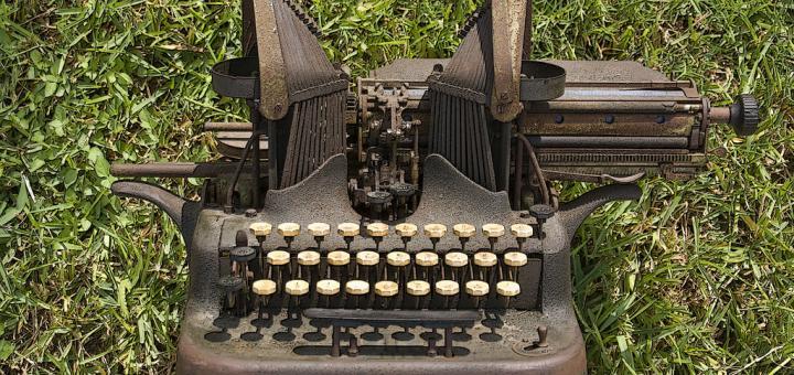Old-fashioned typewriter on grass.