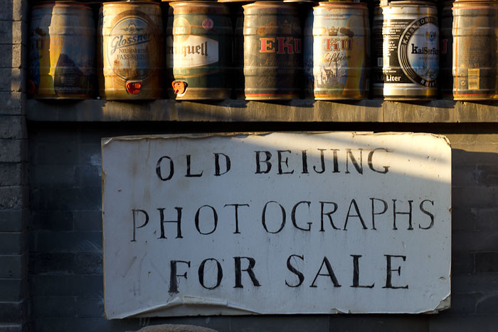 Old Beijing photographs for sale sign and beer cans.