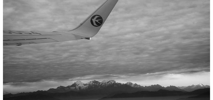Plane wing flying over the Himalayas.