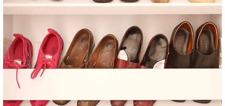 Lines of shoes in a shoe cupboard.