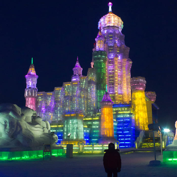 Zac in front of illuminated ice palace in Harbin.