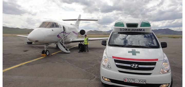 Land ambulance and air ambulance on tarmac.