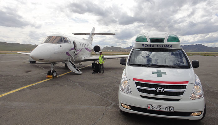 Land ambulance and air ambulance on tarmac.