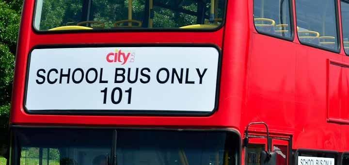 Sign on the front of a red double-decker bus reading "School Bus Only".