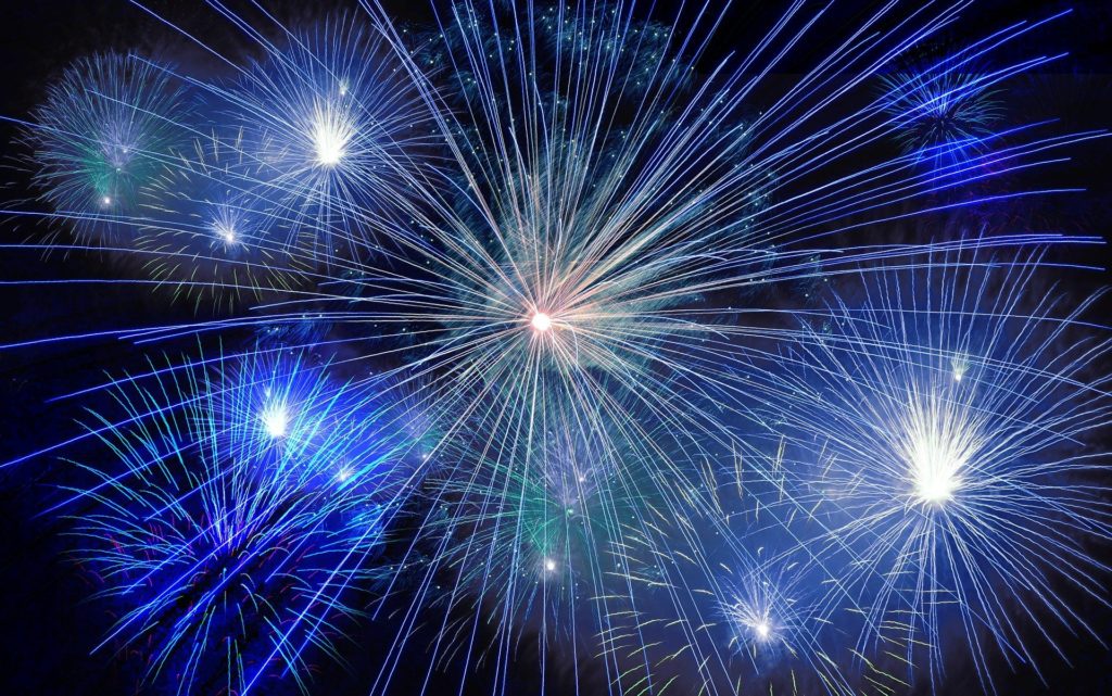 blue fireworks explode in the sky on new year's eve
