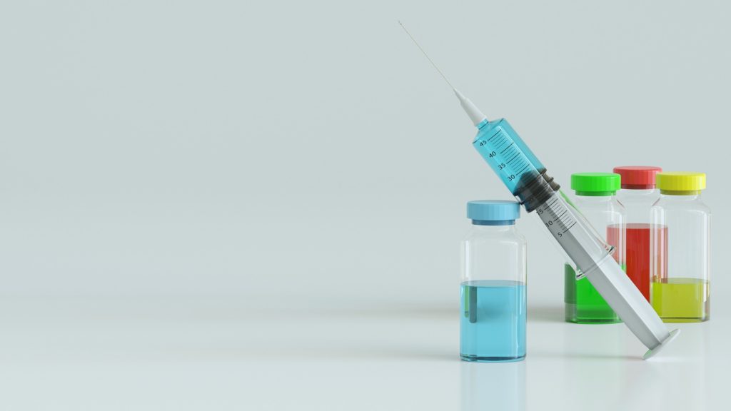 syringe with vials of coloured liquid